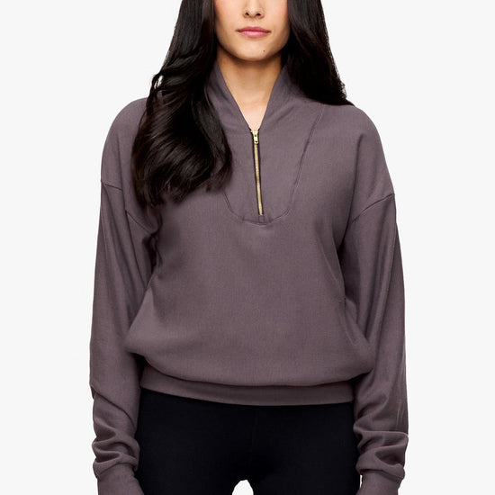 woman wearing a 1/4 zip sweatshirt in deep purple