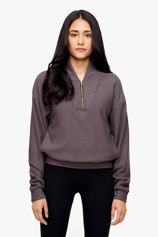 woman wearing a 1/4 zip sweatshirt in deep purple