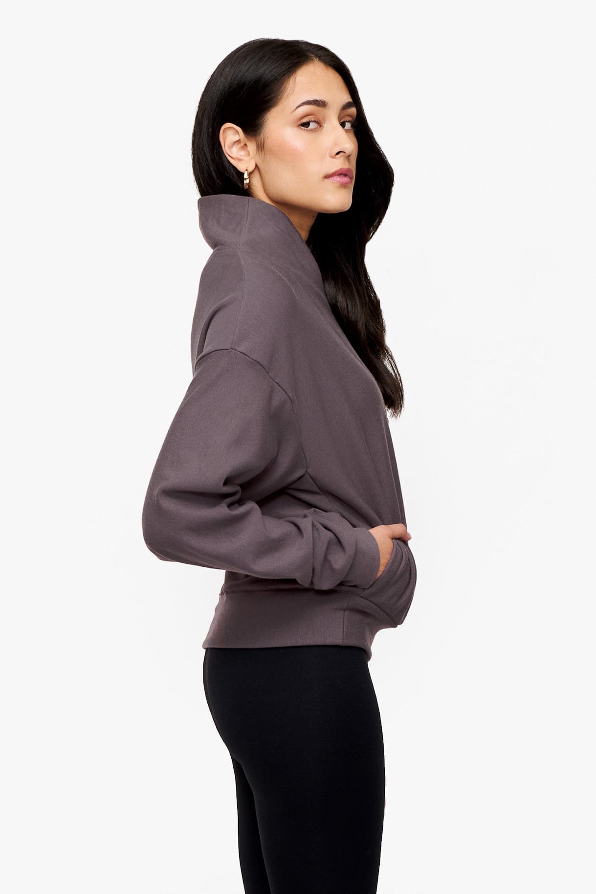 side of a woman wearing a 1/4 zip sweatshirt in deep purple