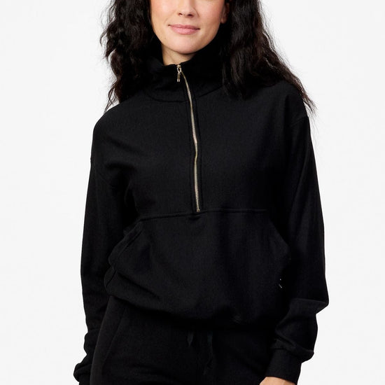 Woman wearing a black half zip sweatshirt