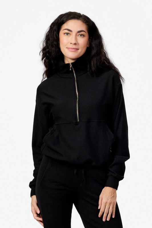Woman wearing a black half zip sweatshirt