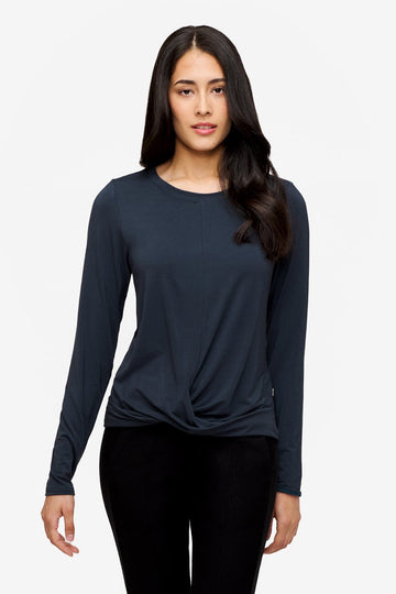 Woman wearing a long sleeve shirt with a twist at the front in dark blue