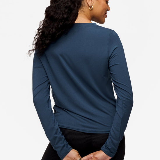 back of a woman wearing a long sleeve shirt with a twist at the front in  blue