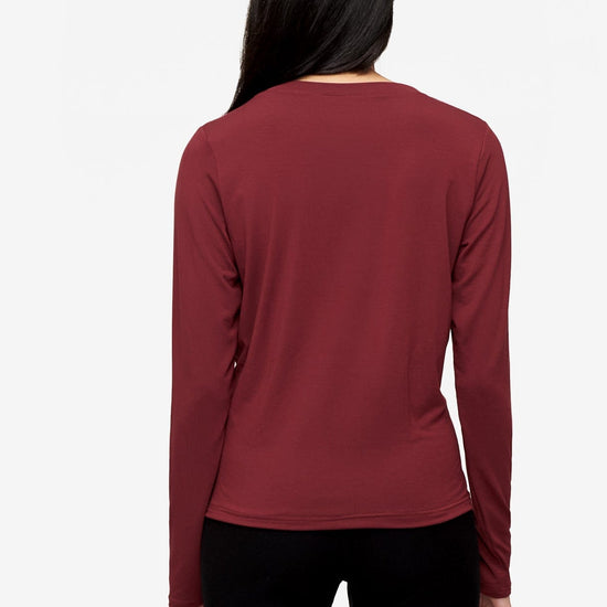 back of a woman wearing a long sleeve shirt with a twist at the front in  deep red