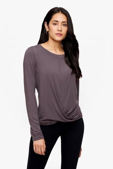 woman wearing a long sleeve shirt with a twist at the front in deep purple