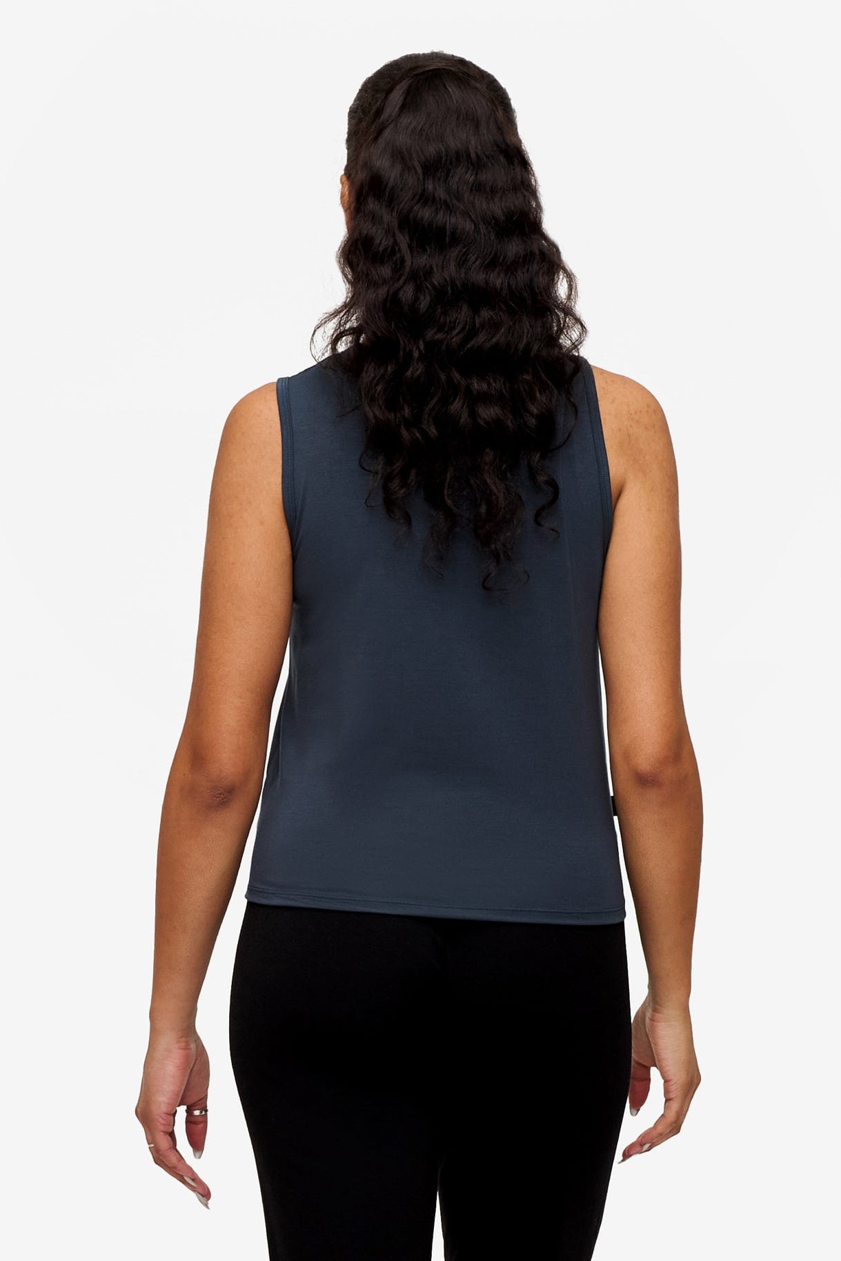 back of a woman wearing a sleeveless shirt with a twist at the front in dark blue