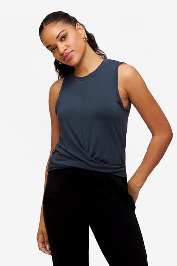 woman wearing a sleeveless shirt with a twist at the front in dark blue