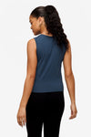 back of a woman wearing a sleeveless shirt with a twist at the front in deep blue