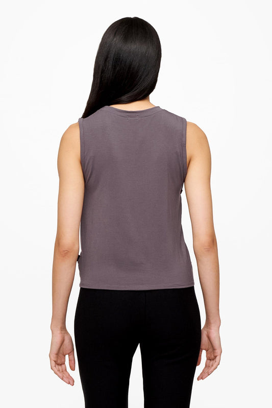 back of a woman wearing a sleeveless shirt with a twist at the front in deep purple