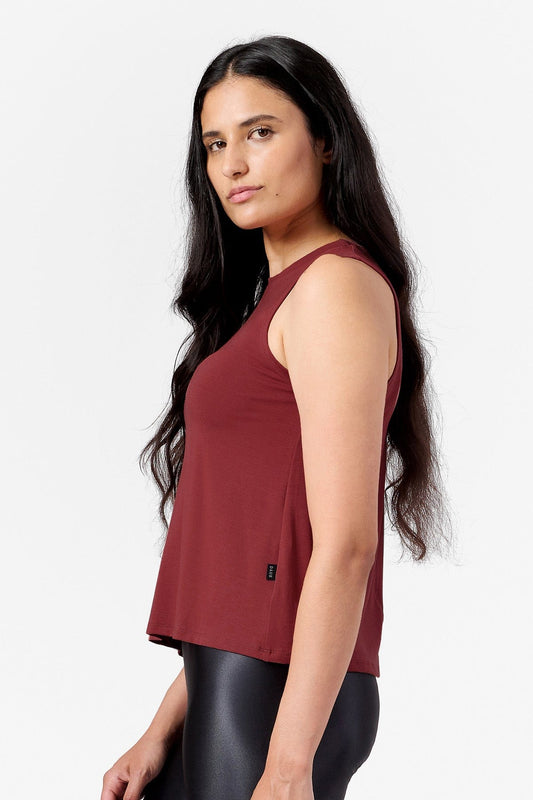 This photo shows a brunette model wearing a burnt red sleeveless tank top.