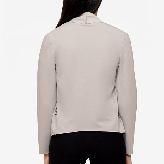 back of a woman wearing a light grey jacket 