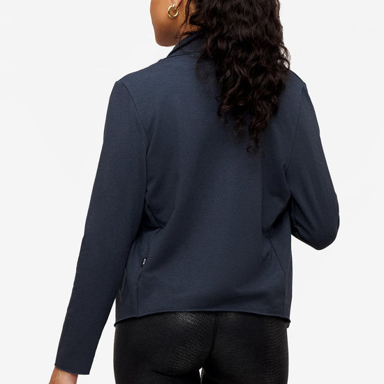 back of a woman wearing a dark blue jacket 