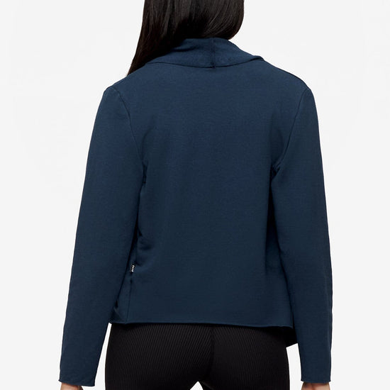 back of a woman wearing a deep blue jacket 