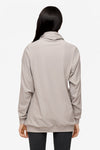 back of a woman wearing a turtleneck sweater in light grey