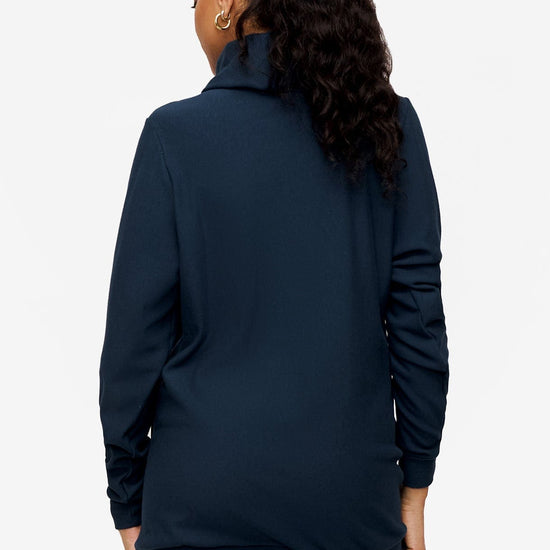 back of a woman wearing a turtleneck sweater in blue