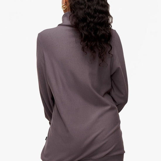 back of a woman wearing a turtleneck sweater in deep purple