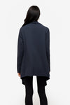 back of a woman wearing a drapey jacket in dark blue