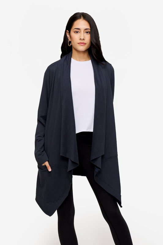 woman wearing a drapey jacket in dark blue