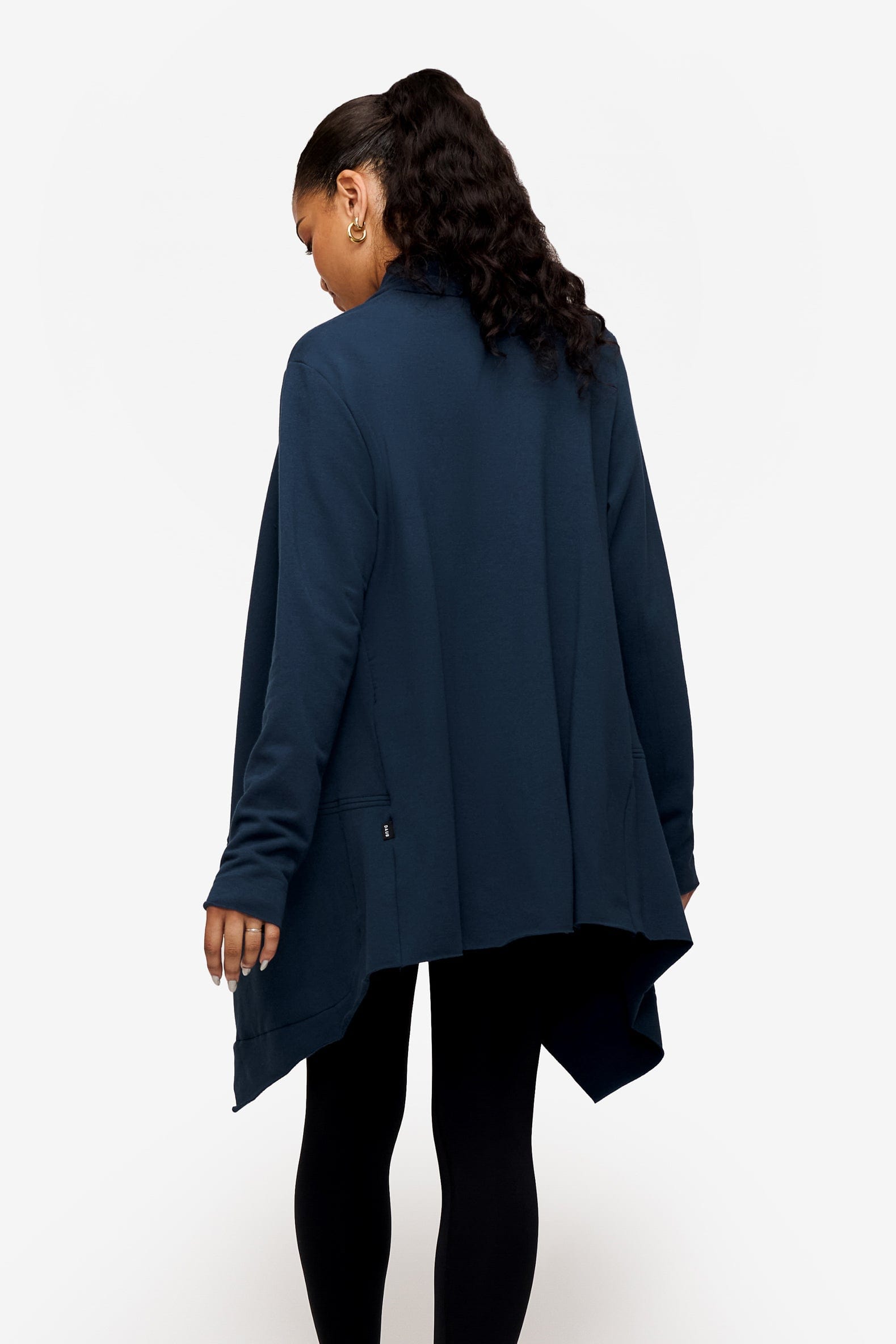 back of a woman wearing a drapey jacket in deep blue