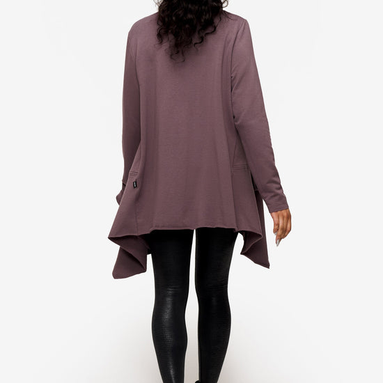 back of a woman wearing a drapey jacket in deep purple