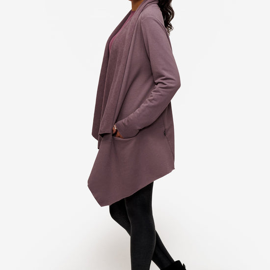 side of a woman wearing a drapey jacket in deep purple