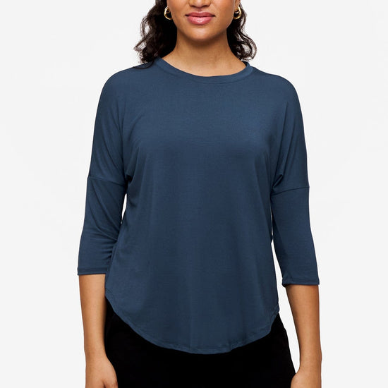 Woman smiling wearing a bright blue 3/4 sleeve shirt