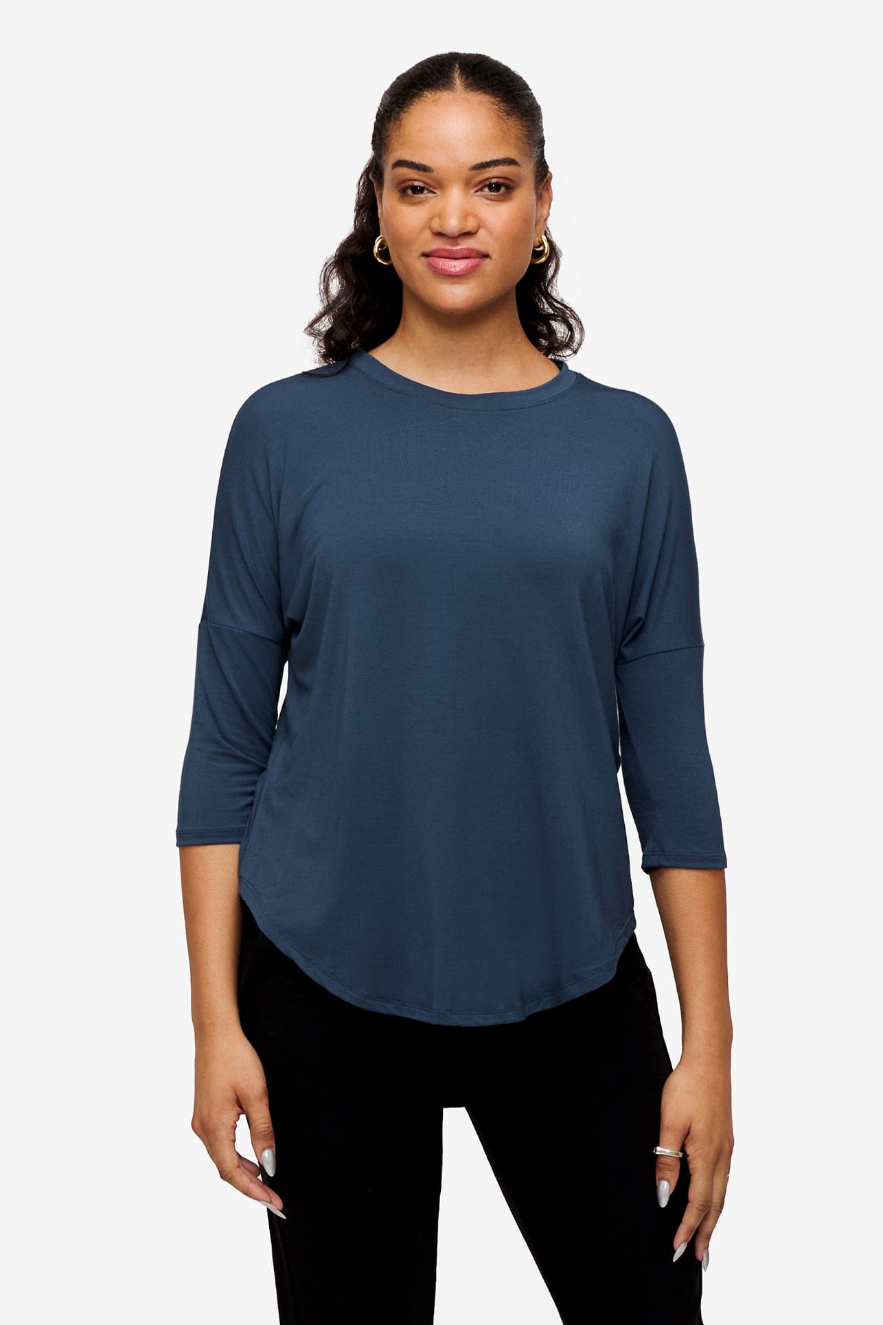 Woman smiling wearing a bright blue 3/4 sleeve shirt
