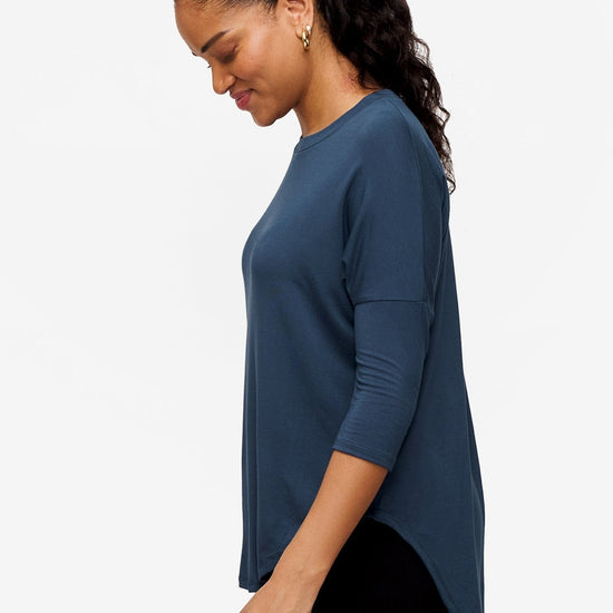 Side of a Woman wearing a bright blue 3/4 sleeve shirt