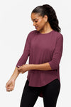 woman wearing a deep pink 3/4 sleeve shirt while looking down