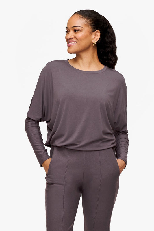 woman wearing a deep purple loose sleeve long sleeve shirt