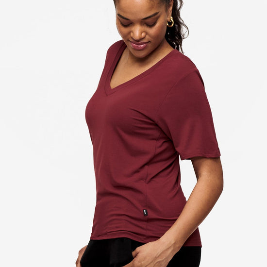 side of woman wearing deep red v-neck short sleeve t-shirt