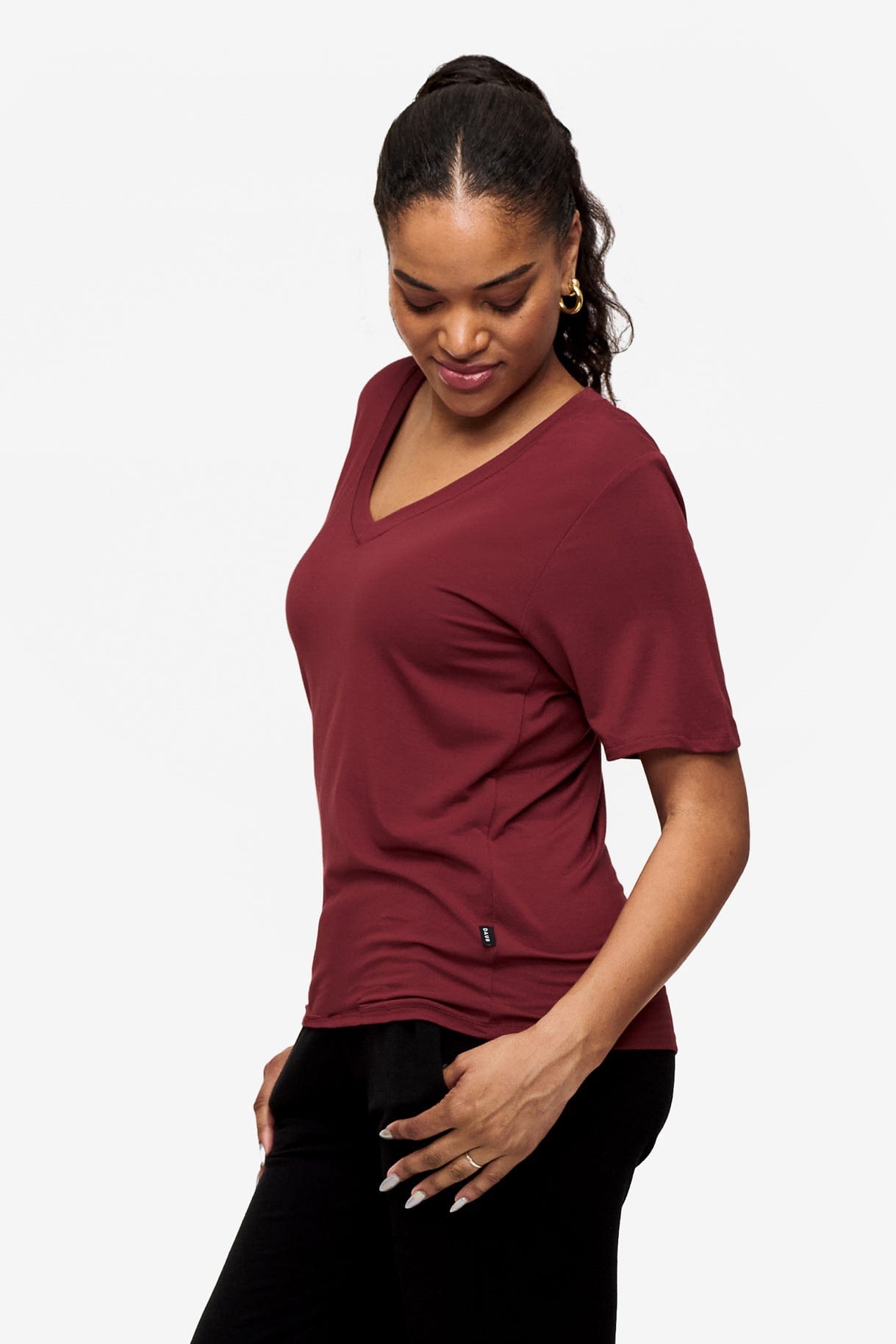 side of woman wearing deep red v-neck short sleeve t-shirt