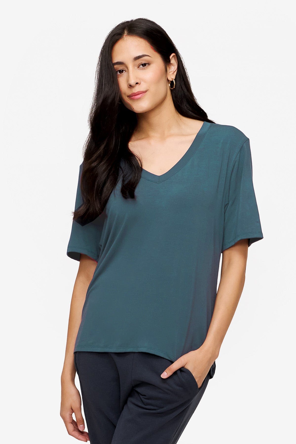 A woman wears a v-neck tee shirt in a turquoise colour