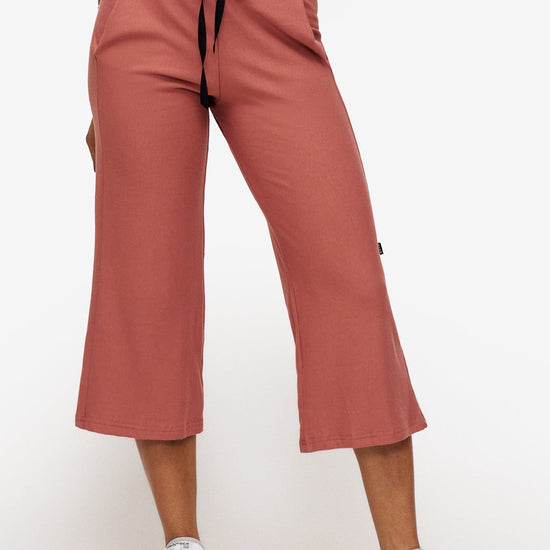 woman wearing orange cropped sweatpants with drawstring 