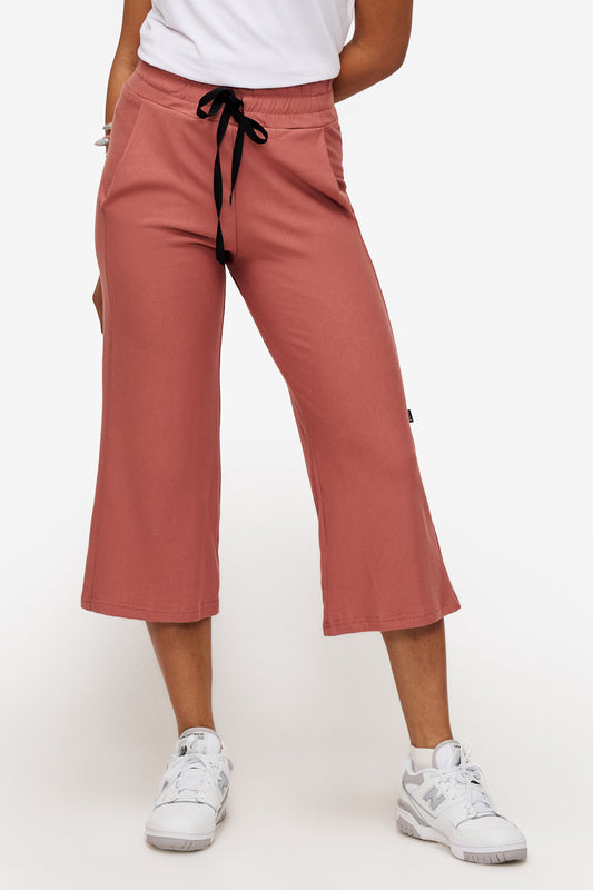 woman wearing orange cropped sweatpants with drawstring 