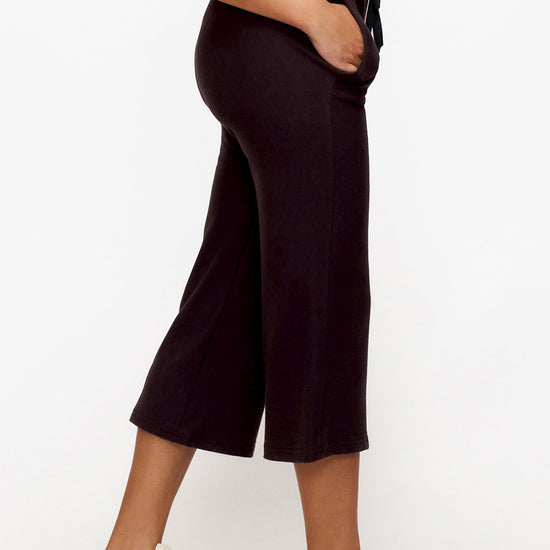 side of a woman wearing brown cropped sweatpants with drawstring 