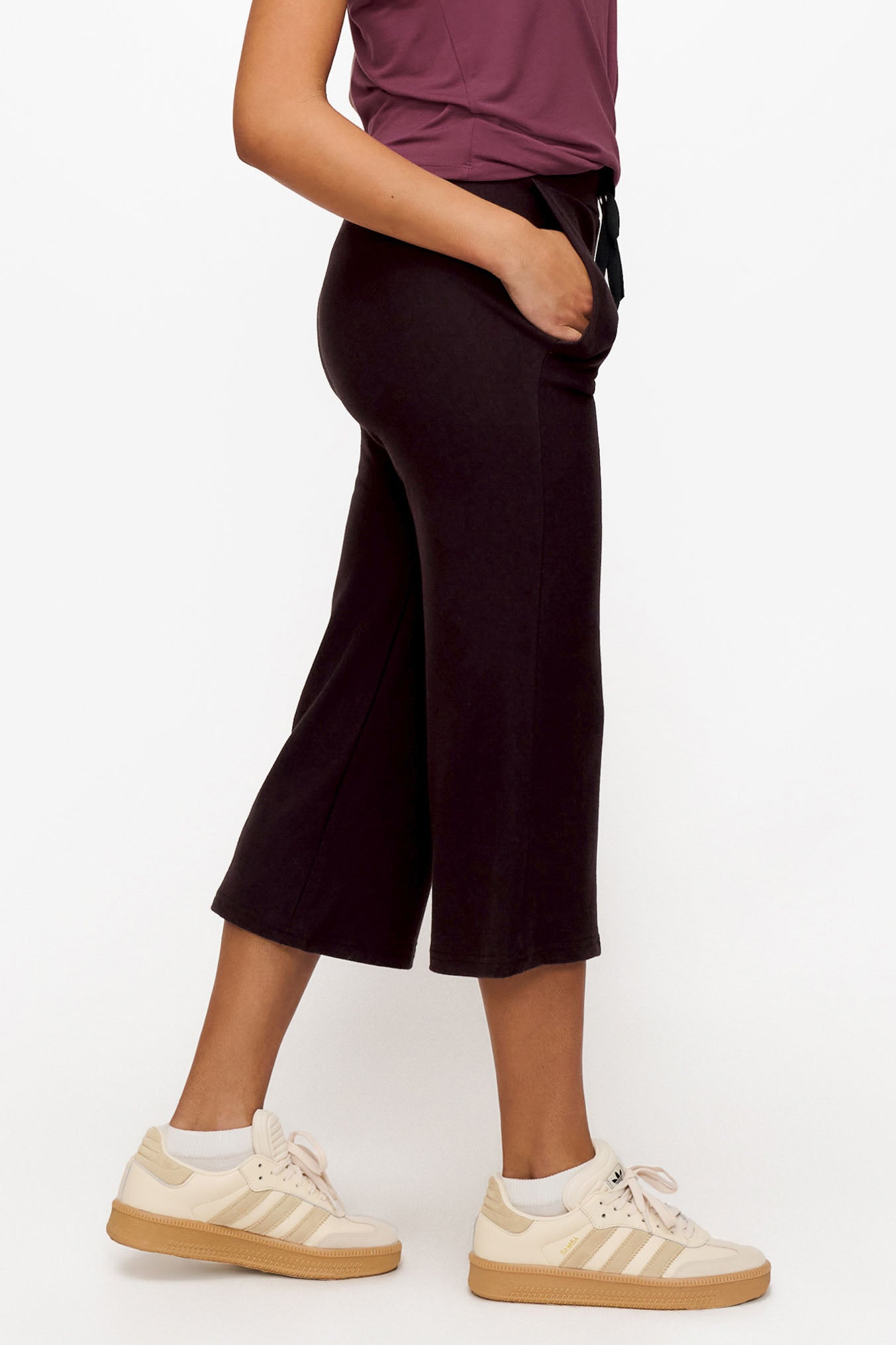 side of a woman wearing brown cropped sweatpants with drawstring 