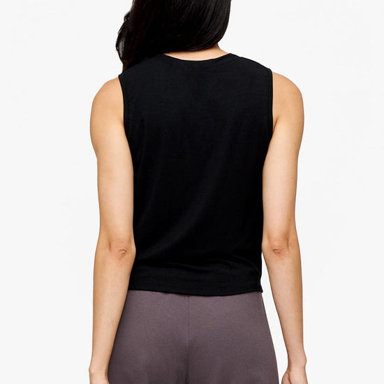 back of a woman wearing a sleeveless shirt with a twist at the front in black