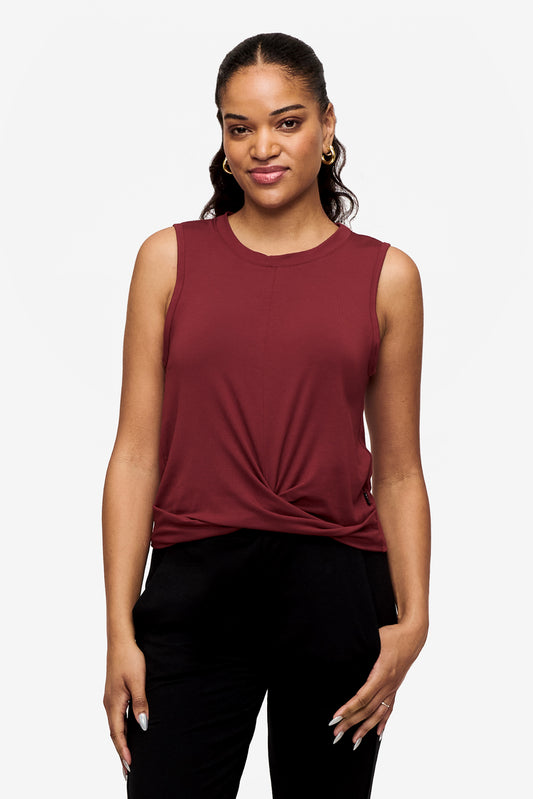 woman wearing a sleeveless shirt with a twist at the front in deep red