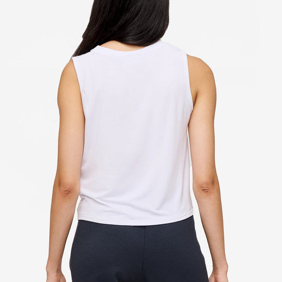 back of a woman wearing a sleeveless shirt with a twist at the front in white