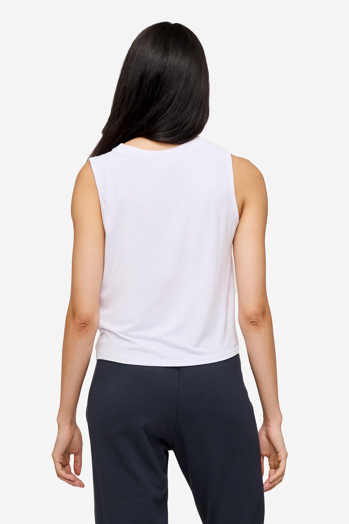 back of a woman wearing a sleeveless shirt with a twist at the front in white