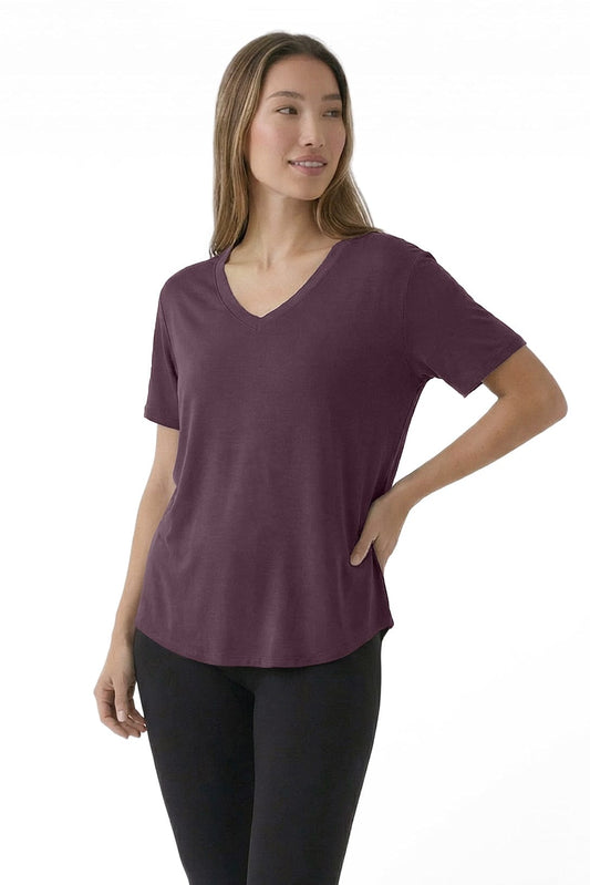 Woman wearing a purple t-shirt and black pants on a white background