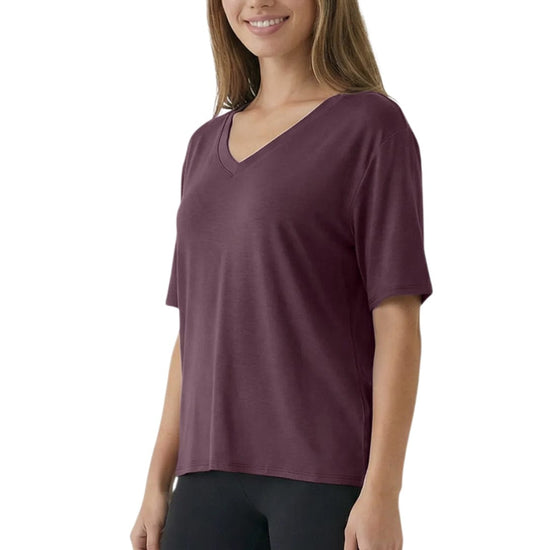 Woman wearing a maroon t-shirt and black pants on a white background