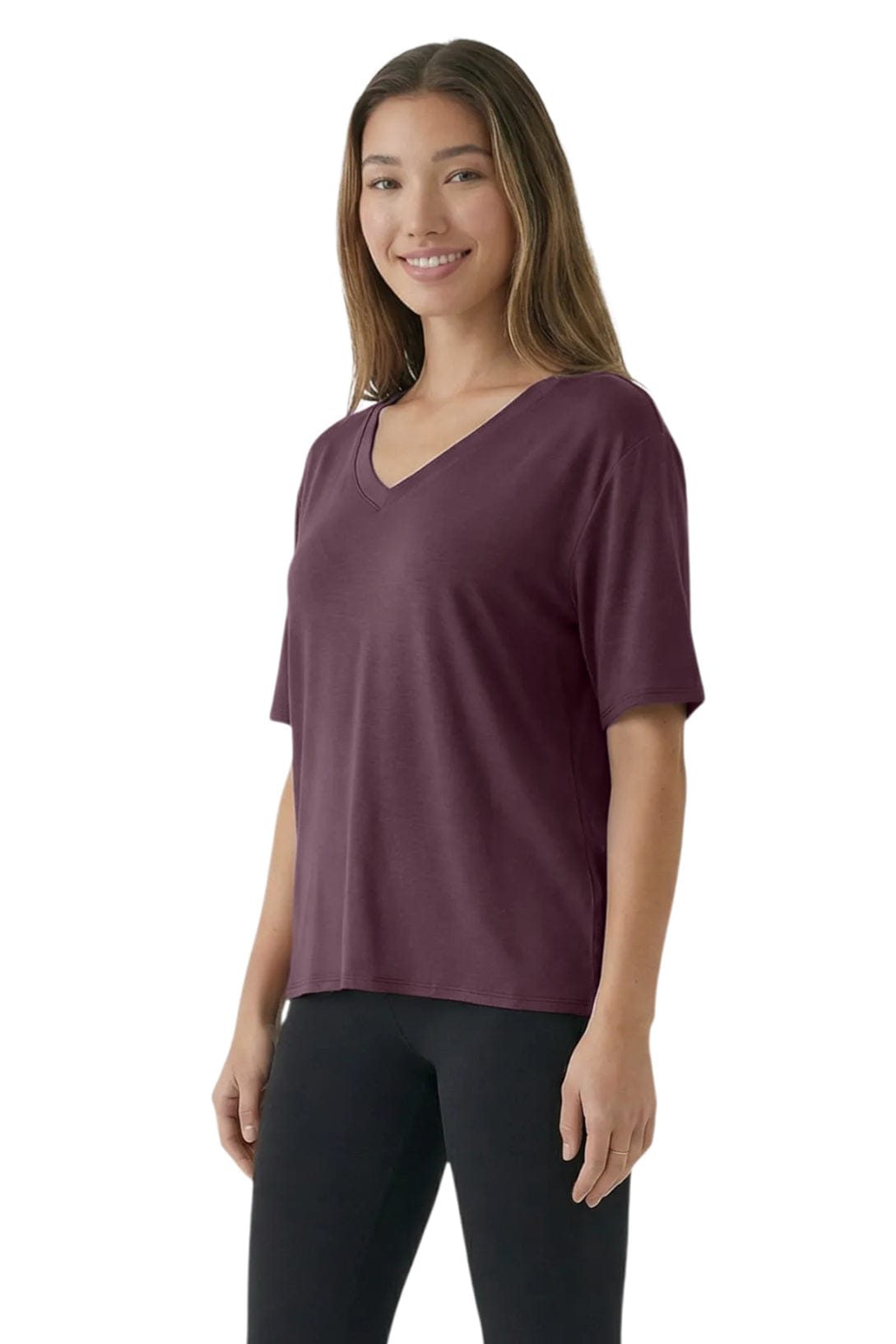 Woman wearing a maroon t-shirt and black pants on a white background