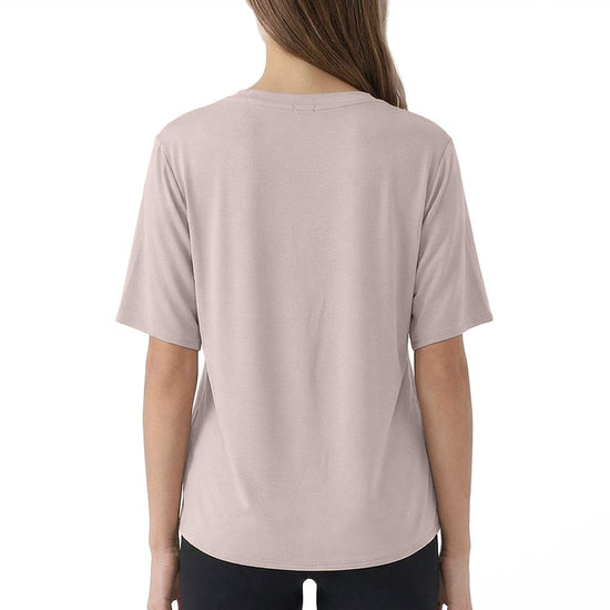 Woman wearing a light pink t-shirt and black pants on a white background