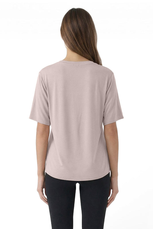 Woman wearing a light pink t-shirt and black pants on a white background