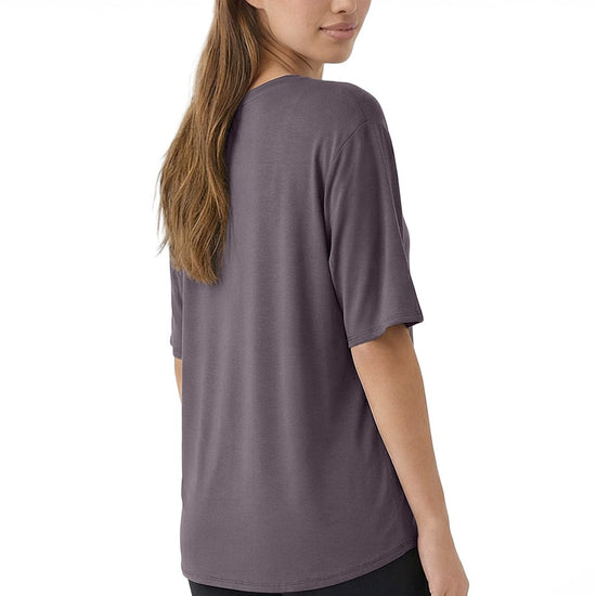 Woman wearing a gray t-shirt and black leggings on a white background