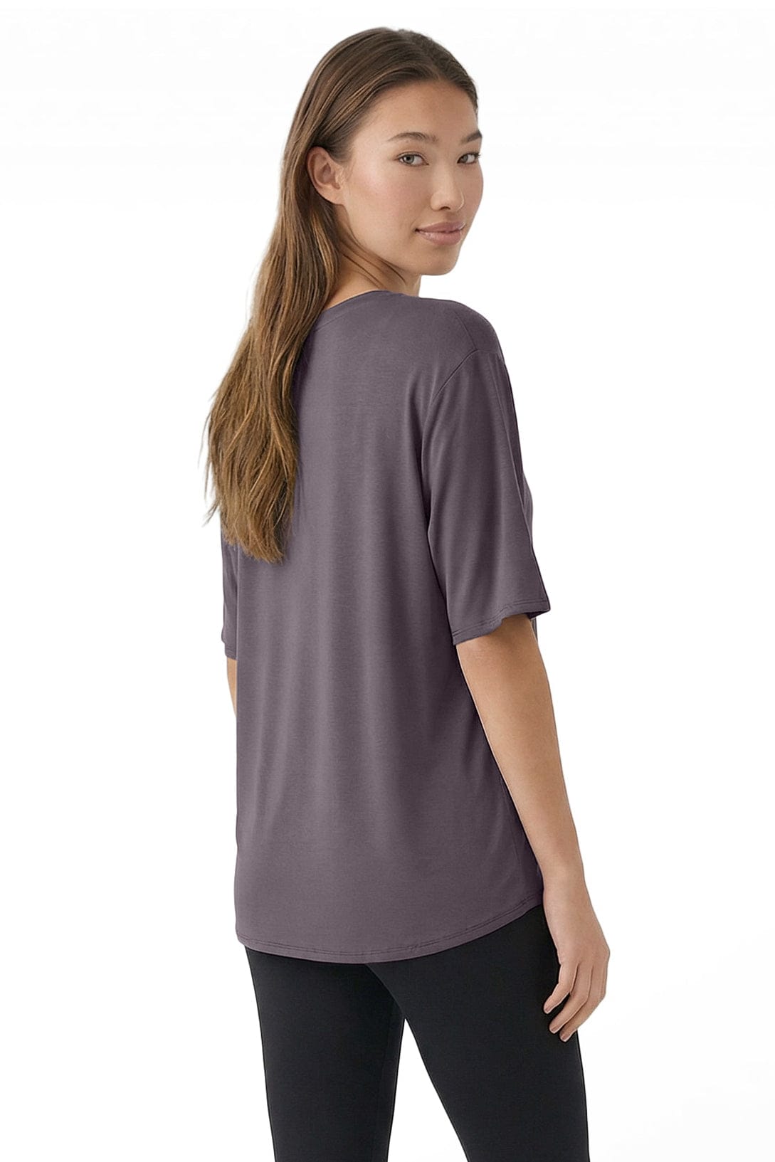 Woman wearing a gray t-shirt and black leggings on a white background