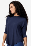 Side of a woman wearing a navy 3/4 length sleeve shirt