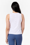 Back of a woman wearing a white tank and blue ribbed leggings